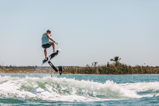 Wakefoiler catching air off the wake, ollieing the wake on a Ronix foil board for smooth lift and glide.