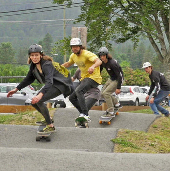 Four friends riding Sanford Shapes cruiser skateboards on a pump track. Handcrafted wood decks, no prints, built for smooth cruising. Skateboard collection photo from Wakesports.com.