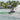 Rider performing a powerful heelside slash on the versatile 2026 Ronix District wakeboard.
