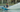 Man water skiing behind a boat with a blue water ski