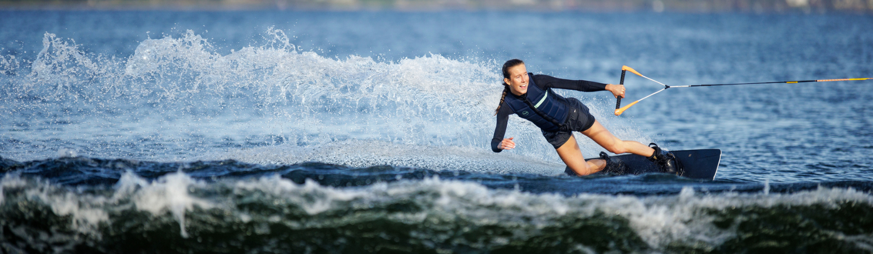 Woman wakeboarding and holding onto a wakeboard rope