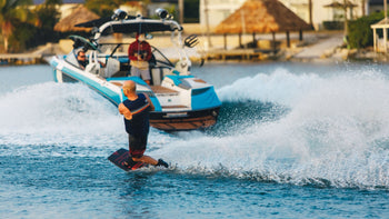 A man edging outside of the wake heelside on the new 2026 Ronix Vault beginner wakeboard behind a boat. 