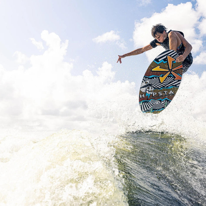Pro wakesurfer catching air with a clean ollie nose grab on the Phase 5 Hypsta.