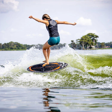 Pro rider Whitley Stewart spinning a technical 360 shuv-it mid-air on her Phase 5 Key pro model wakesurf board.