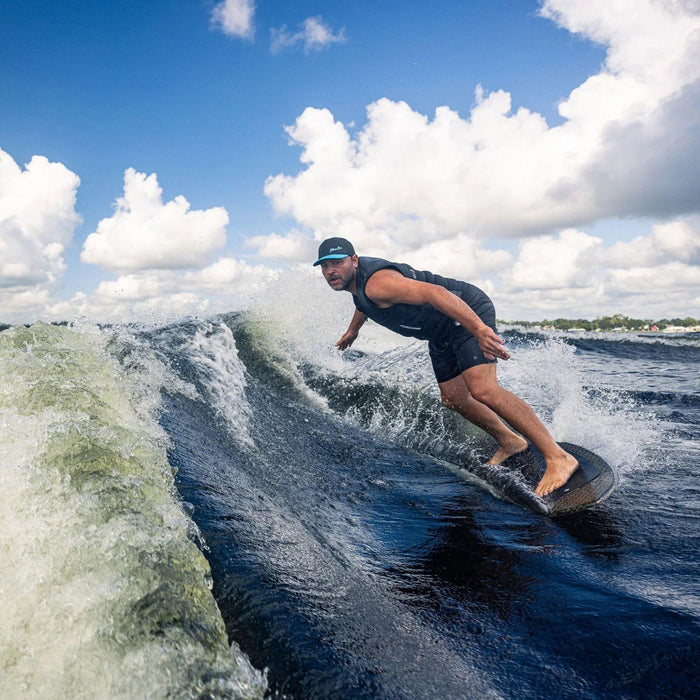 Wakesurfer executing a deep bottom turn at the base of the wave on the Phase 5 Model X LTD.