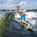 Wakesurfer executing a powerful bottom turn at the base of the wave on the Phase 5 Model X Wakesurf Board.