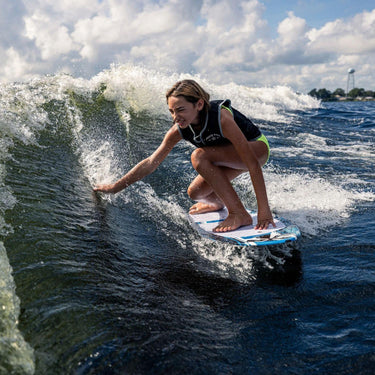 Young girl grom touching the water while surfing the sweet spot on the Phase 5 Scamp.