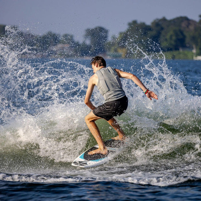 Male wakesurfer throwing a huge spray with a powerful slash on the 2026 Phase 5 Swell.
