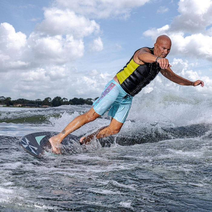 Wakesurfer executing a deep, powerful bottom turn at the base of the wave on the Phase 5 Trident.