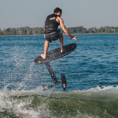 Expert wakefoiler launching high into the air off the crest of the first wake using the Ronix Expert 29" Velo Mast with Blackbird board carbon complete wakefoil setup.