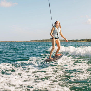 Pro rider Kira Lewis tracking hard on the first wave with the tow rope in hand using the Ronix intermediate 727 balance series complete wakefoil package.