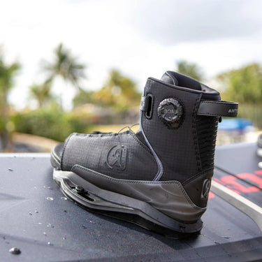 Close-up lifestyle shot of the Ronix Anthem BOA boot mounted on a District wakeboard, showing the seamless board-to-boot connection.