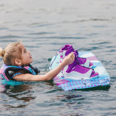 Young girl grom in the water with her 2026 Ronix August board and boot package, ready for her first set.