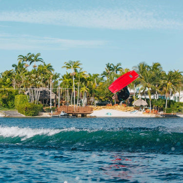Rider utilizing the 2026 Ronix District wakeboard package to learn a wake-to-wake backroll invert.