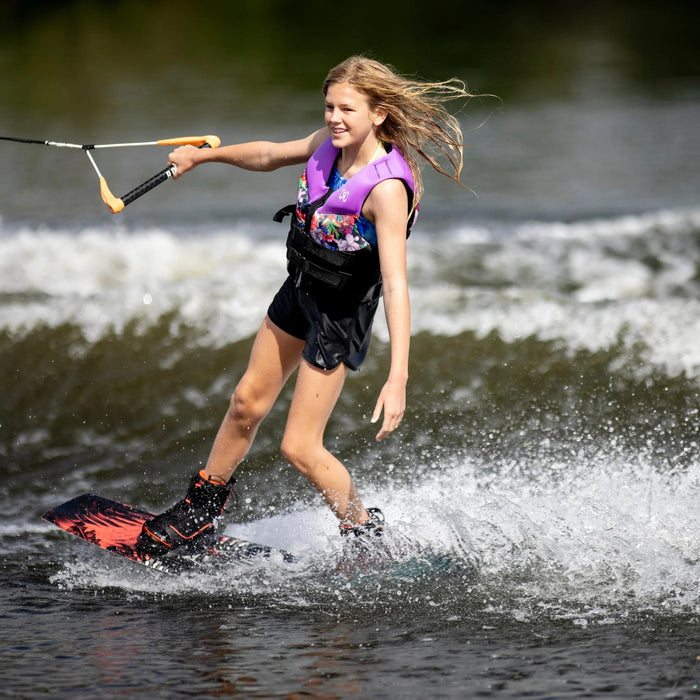 Young teen girl riding the Ronix Krush one-handed with a smile, demonstrating confidence and balance.
