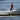 Young grom wakeboarder confidently executing a tailgrab in the air on the complete 2026 Ronix Kid's Vault wakeboard package.