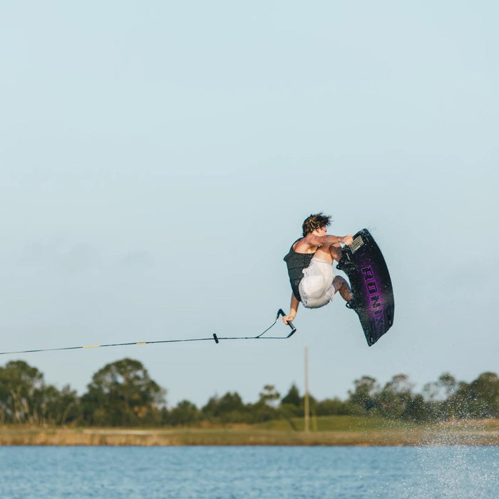 Tyler Higham executing a technical spin with a tail grab on the responsive Ronix One Blackout wakeboard.