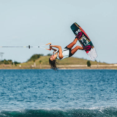 Pro female rider, Giulia Castelli, launching a massive wake-to-wake inverted air on her complete 2026 Ronix Rise wakeboard package.