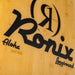 Close-up of the Ronix Aloha logo on the wood grain bottom of the Marsh Mellow longboard.