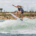 Advanced female rider performing an ollie nose grab air on the 2026 Ronix Aura Flyweight skimmer.