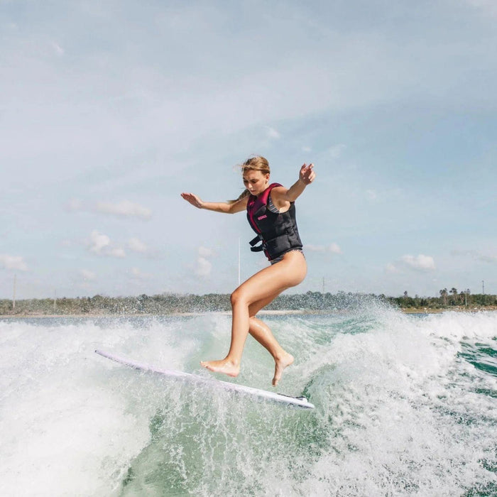 Female rider demonstrating the technical agility of the Ronix Aura skimmer with a smooth shuv-it rotation.