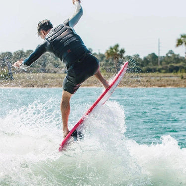 Rider catching air off the wake on a 2026 Ronix DNA Flyweight Pro wakesurf board.