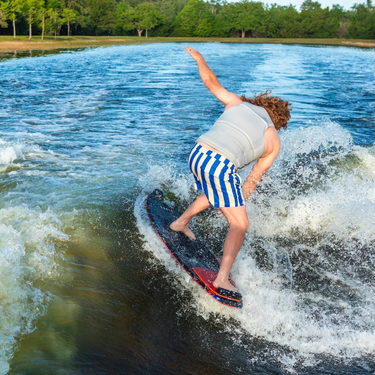 Pro rider Parks Bonifay performing a surface 360 on the 2027 Ronix M50 Dark Matter Wakesurfer, demonstrating its versatile cheese grater fin feel.
