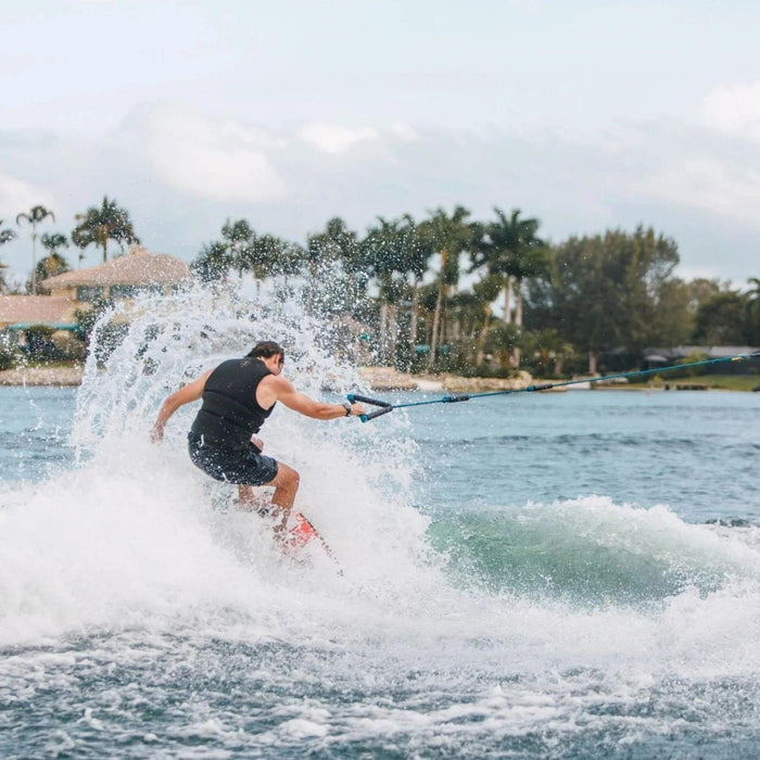 Rider holding the rope and throwing a big spray on the Ronix Standard Core Skimmer.