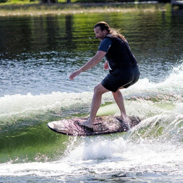 Large rider cruising effortlessly without a rope on the high-volume Ronix Wave King XL Skimmer.