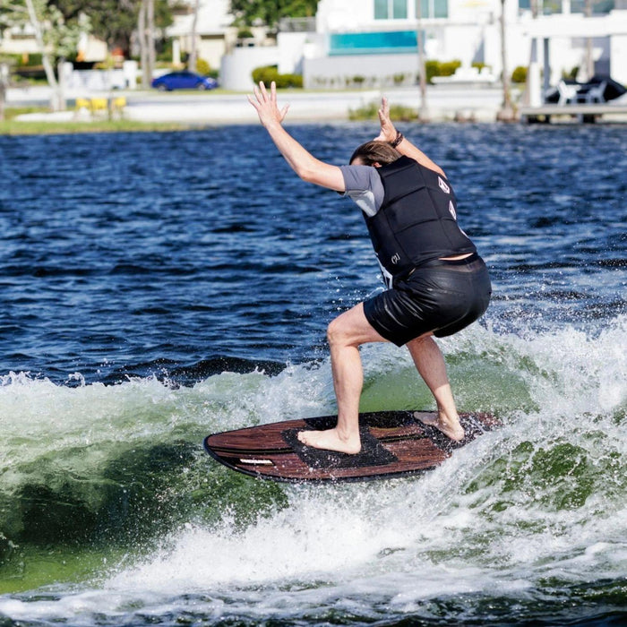 Rider celebrating in the sweet spot of the wake on the stable Ronix Wave King XL Skimmer.