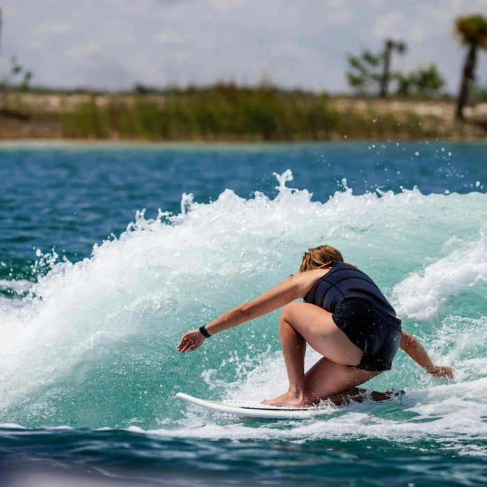 Female wakesurfer crouching low in the sweet spot for stability on a Ronix Women's Fish.