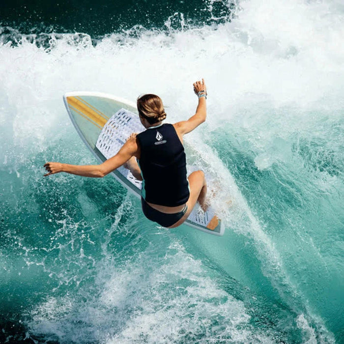 Female rider performing a stylish heelside slash on the 2026 Ronix Women's Fish wakesurfer.