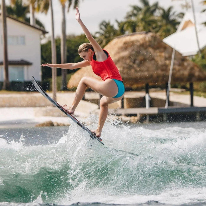 Female rider catching air on the performance-oriented Ronix Women's Sea Captain Tuff Tech.